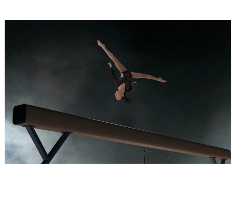 Gymnast performing somersault on beam