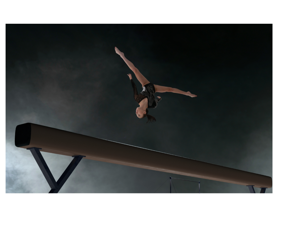 Gymnast performing somersault on beam